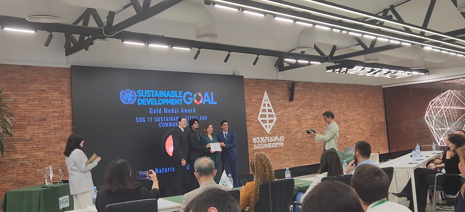 Naturista receiving the Sustainable Development Goal Gold Medal Award for SDG 11 at the SAGE World Cup